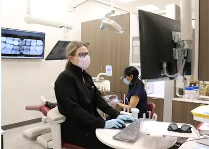 receptionist talking with patient at front desk of dentist in leduc, ab
