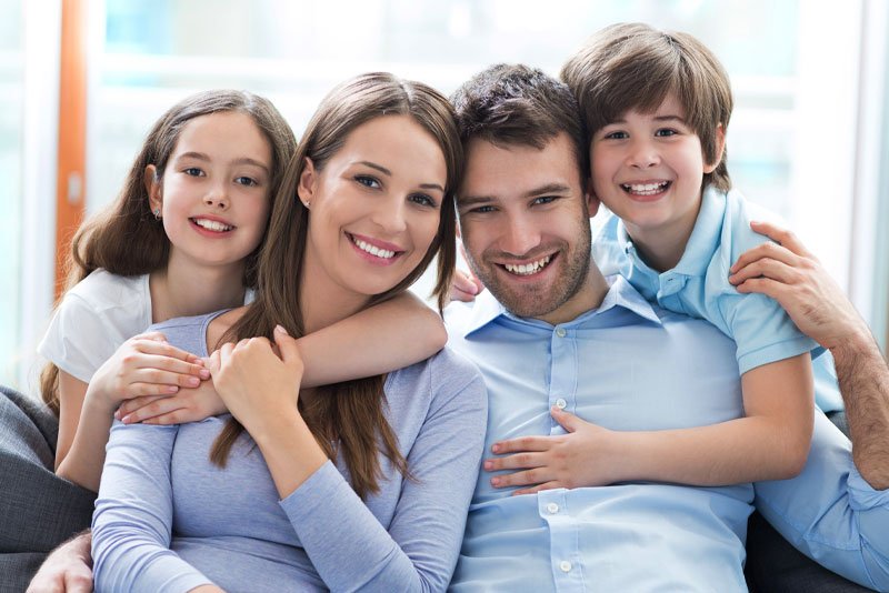 image of a family smiling after going to a family dentistry dentist inn Pearl, MS called Key Dental Group.